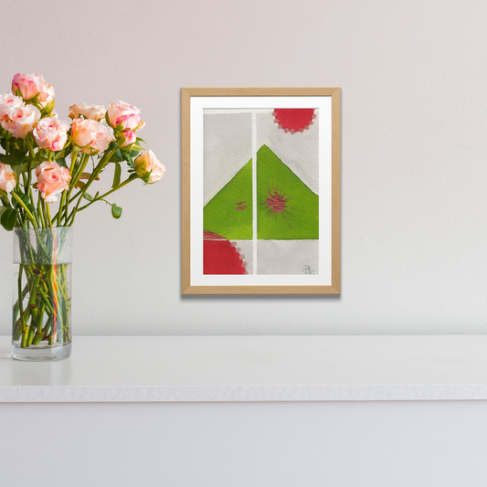 Framed abstract art piece on a wall with a vase of flowers next to it.