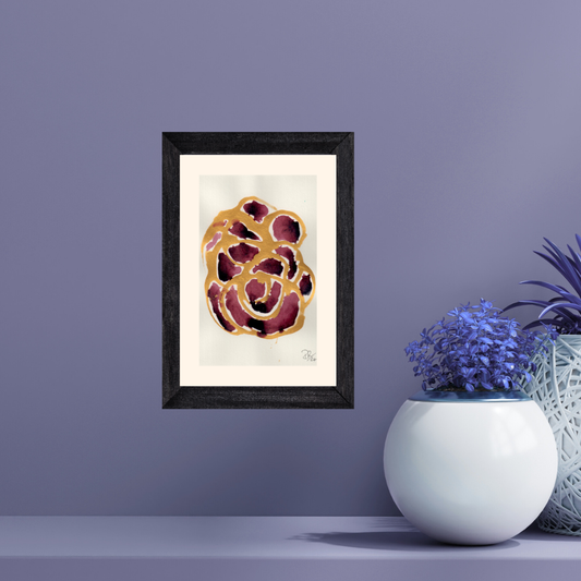Framed abstract art piece on a purple wall with decorative plants.