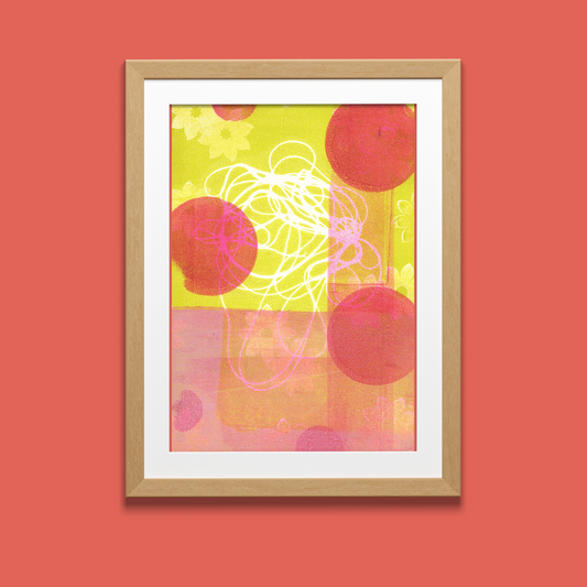 Framed abstract art with red and yellow circles on a red wall