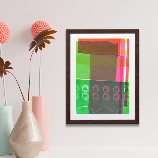 Framed abstract art piece on a wall with decorative vases and plants.