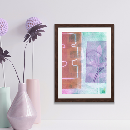 Framed abstract art piece on a wall with decorative vases and plants.