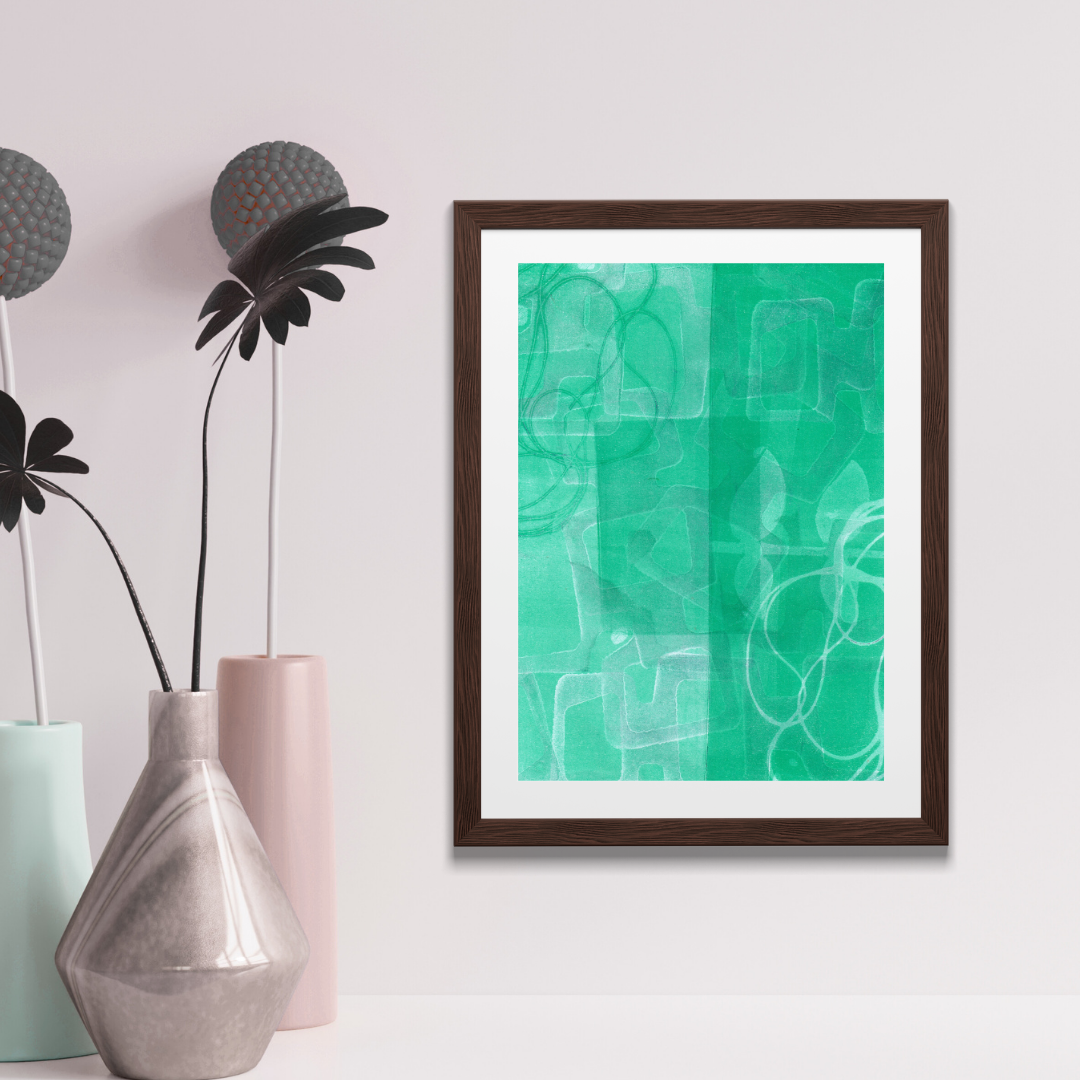 Framed abstract art with a green and white design on a wall next to decorative vases and plants.
