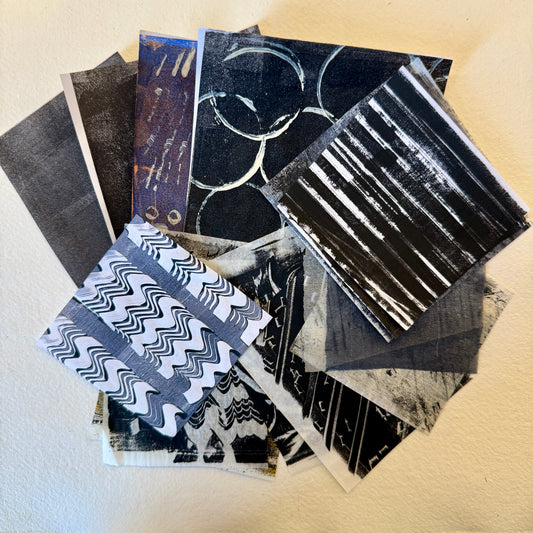 Collection of black and white patterned paper pieces on a beige surface