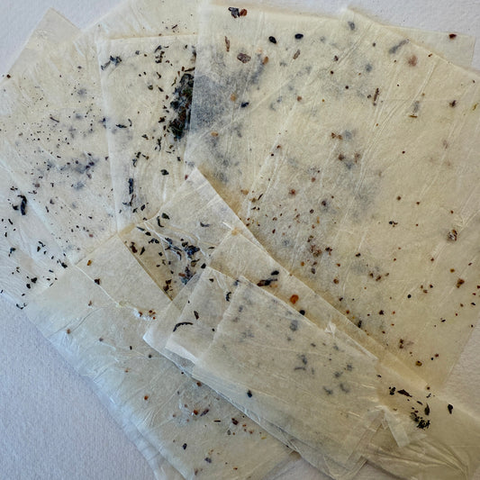 pieces of textured tissue paper containing seeds and tea leaves