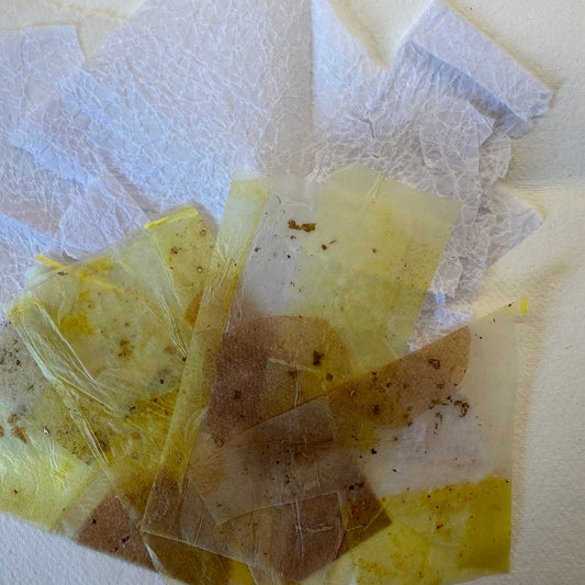 Translucent yellow and brown paper fragments on a white background